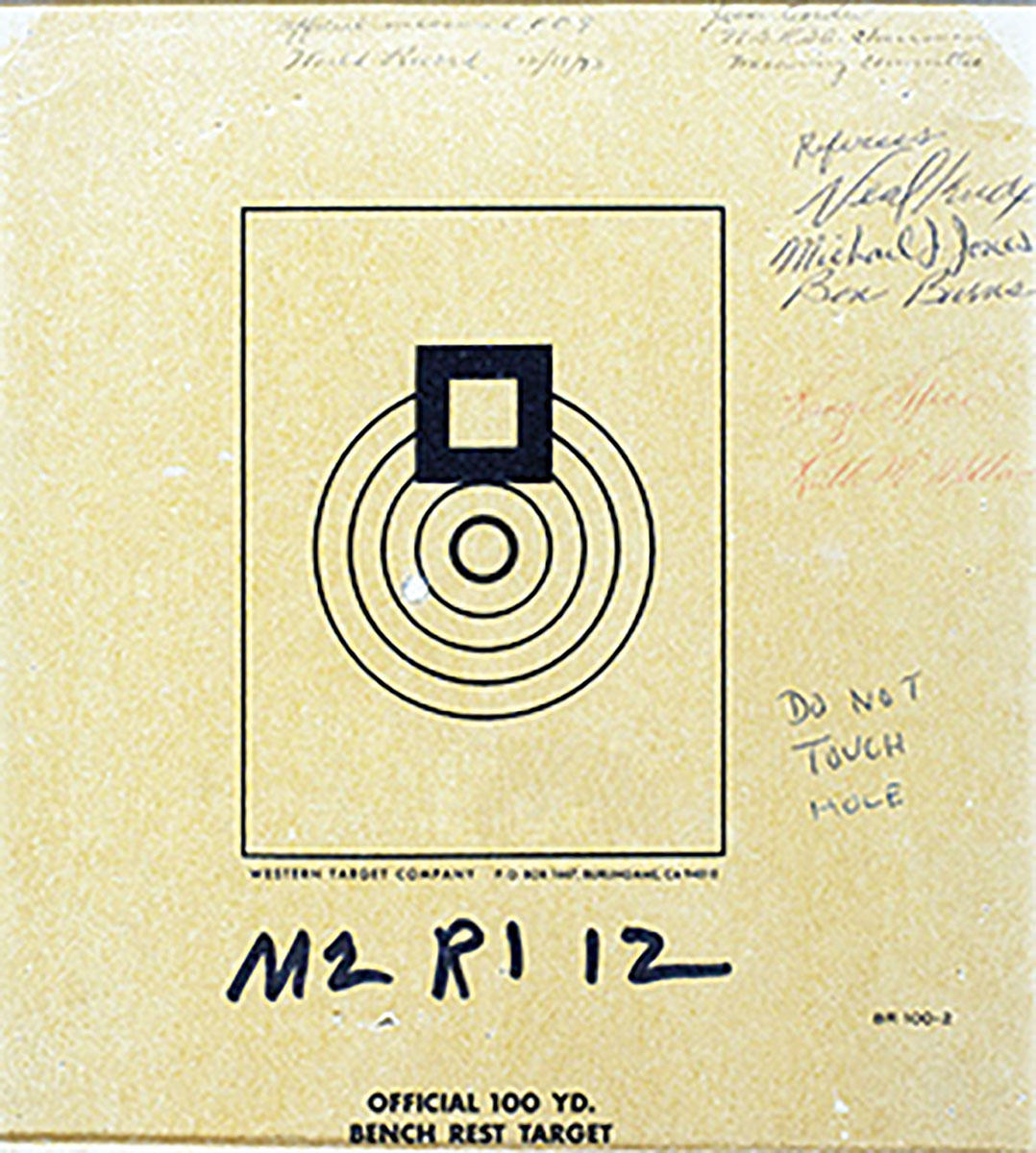 This is the actual target with a one-hole group fired in registered benchrest competition in 1973 by Mac McMillan with a Light Varmint class rifle in 222 Remington. Its official measurement with sophisticated instruments during the match was .0000 inch but after being mailed to seven members of the NBRSA records committee who lived in several areas of the country for examination, the group had grown in size to .009 inch.